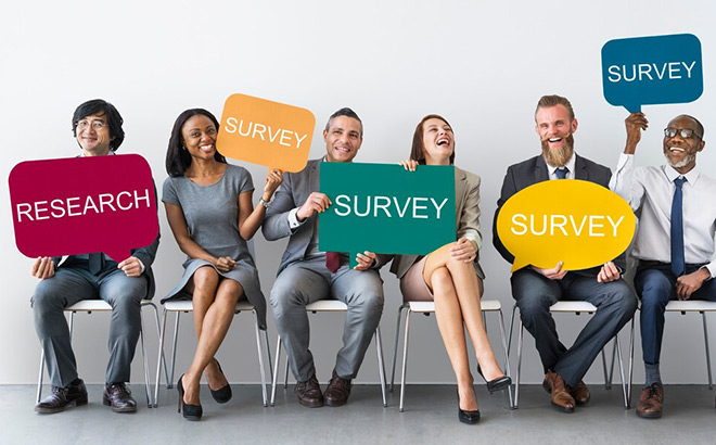 A Group of Seated People Holding Survey Signs