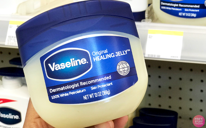 A Hand holding a 13 Ounce Jar of Vaseline Healing Jelly