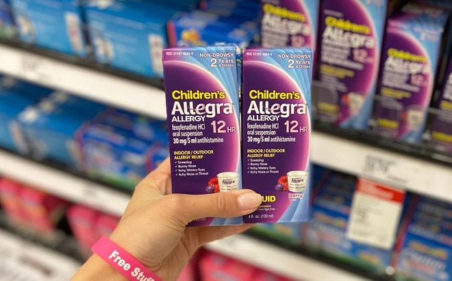 A Person Holding Childrens Allegra 12 Hour Allergy Relief Liquid