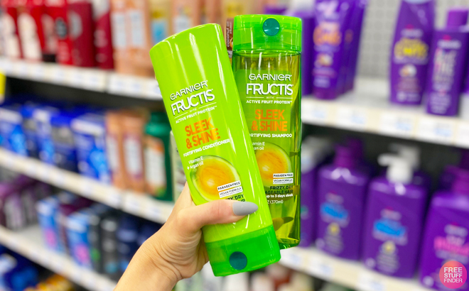 A Person Holding Garnier Fructis Sleek and Shine Shampoo and Conditioner in CVS Store