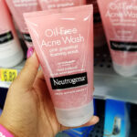 A Person Holding Neutrogena Oil Free Pink Grapefruit Acne Wash Face Scrub