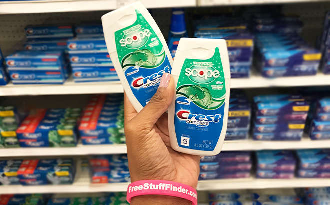 A Person Holding Two Crest Plus Scope Outlast Liquid Gel Toothpastes