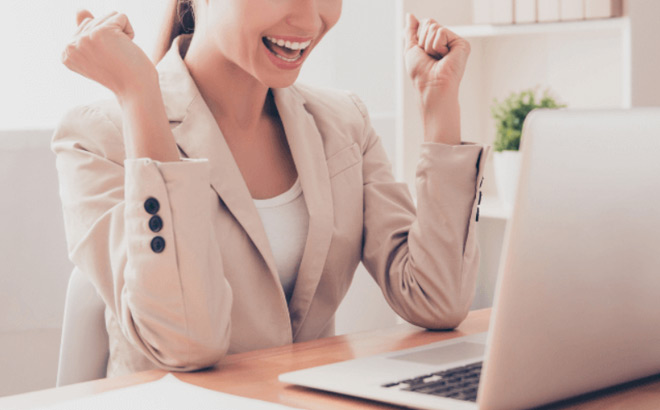 A Person in Front of a Laptop Enjoying Her Success