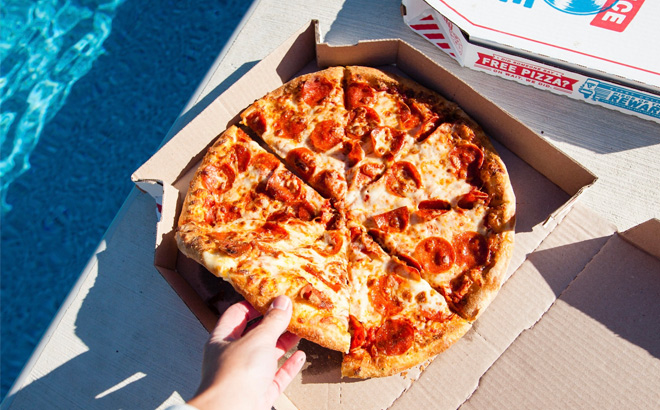 A Person Taking a Slice of Dominos Pizza