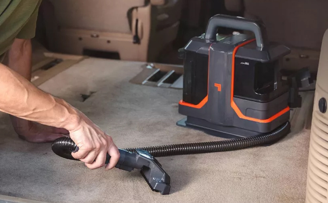A Person Using the Sharper Image Stain Cleaner Portable Spot Vacuum