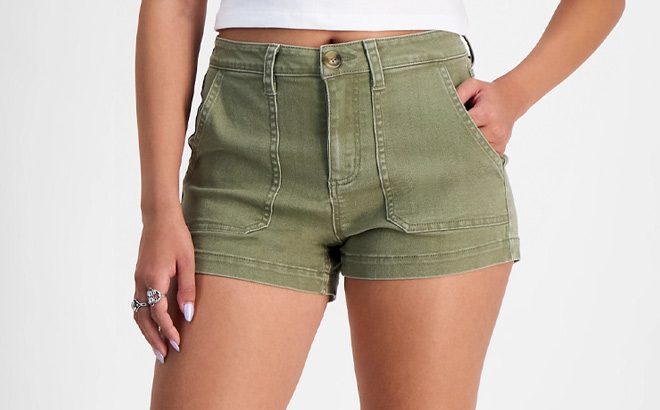 A Person Wearing Indigo Rein Juniors High Rise Utility Pocket Shorts in Cedar Green Color