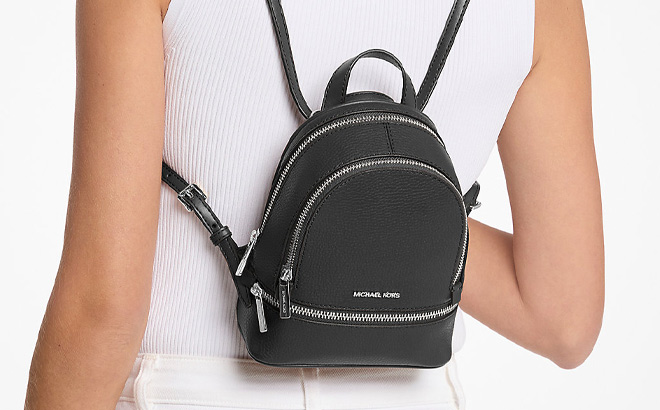 A Person Wearing Michael Kors Outlet Rhea Extra Small Pebbled Leather Backpack