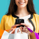 A Woman Holding a Mobile Phone and Several Shopping Bags