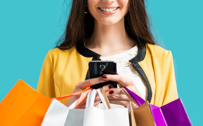 A Woman Holding a Mobile Phone and Several Shopping Bags