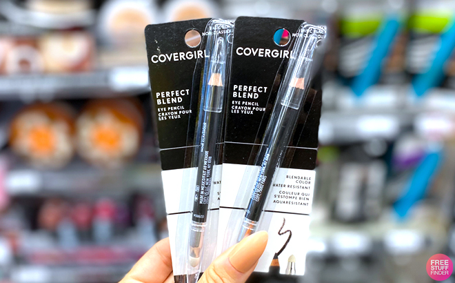 A Hand Holding Two CoverGirl Eye Pencils