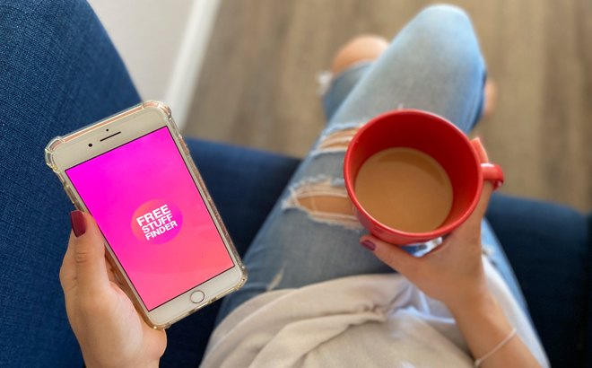 A Person Holding a Phone with FSF App on It in One Hand and Coffee in The Other