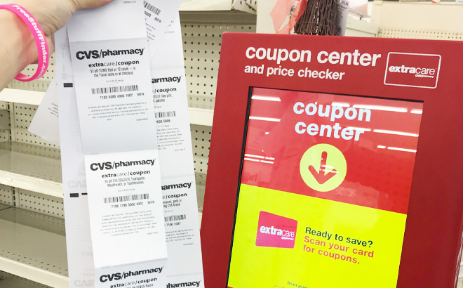 Hand Holding a Receipt in Front of The Red Coupon Machine