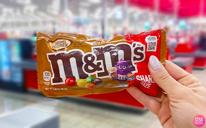Hand holding one MMs candy