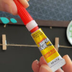 Hands holding a Super Glue