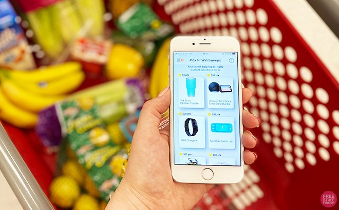 Hand Holding Phone with National Consumer Panel in Front of a Shopping Basket