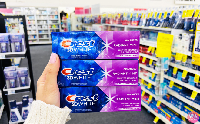 Person Holding Crest 3D White Toothpaste in CVS Store